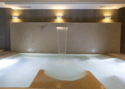 Jacuzzi con cascada iluminada en el Albergue Cruceiro