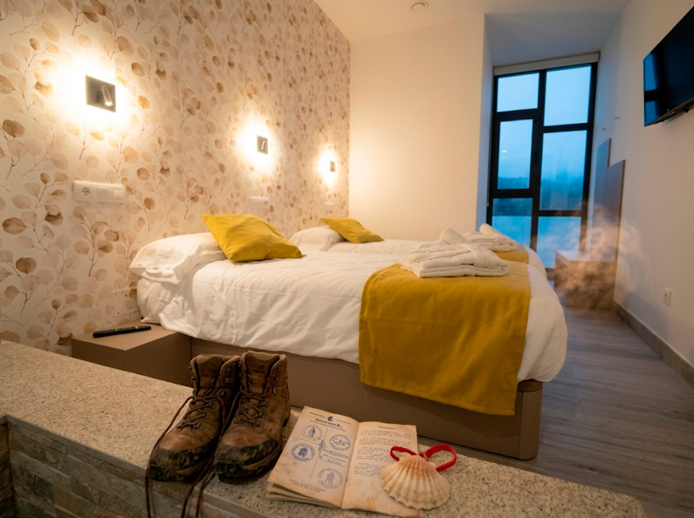 Albergue Cruceiro de Pedrouzo: Habitación privada lista para el descanso del peregrino, con credencial y concha del Camino de Santiago